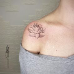 a woman's shoulder with a flower tattoo on it