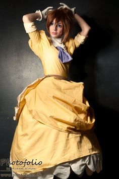 a woman in a yellow dress is posing for the camera with her hands on her head