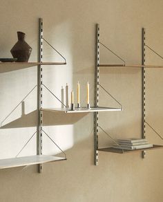 two shelves with candles and books on them in a room that has no one inside