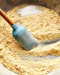 a blue spatula in a bowl filled with flour