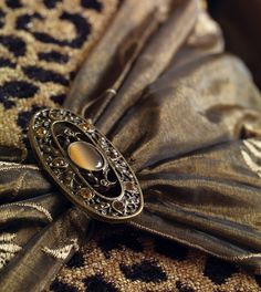 an ornate brooch sits on the fabric