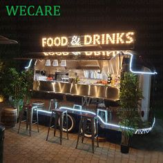 the front of a restaurant with neon lights on it's side and chairs outside