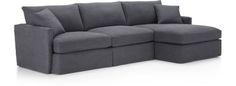 a large gray couch with pillows on it's back and two sides facing each other