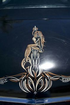 the hood ornament on an old car is decorated with gold and white designs