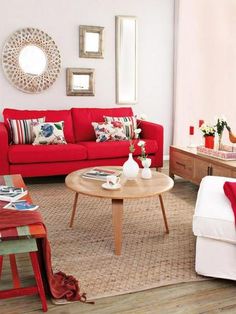 a living room filled with red couches and white chairs next to a coffee table