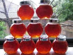 a stack of honey jars sitting on top of a window sill