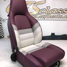 a purple and white car seat sitting in front of a sign that says class cars usa