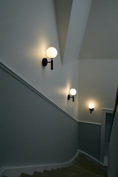 an image of a stairway with lights on the wall and stairs leading up to it