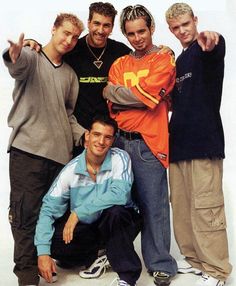 the young men are posing together for a photo in front of a white background,