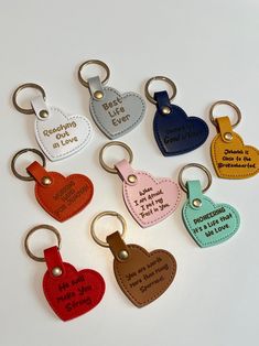 six heart shaped keychains with different sayings on them