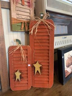 two wooden plaques with stars on them sitting next to a wall mounted heater and microwave