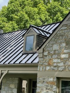 a stone house with a metal roof