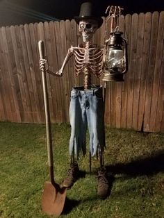 a skeleton is holding a shovel and standing in front of a fence with a lantern