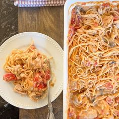 a plate of pasta with chicken and tomato sauce next to a casserole dish