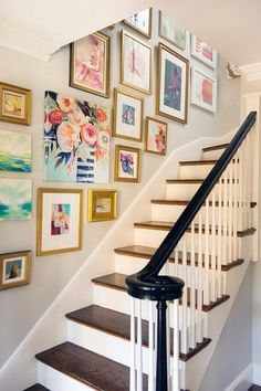 a staircase with pictures on the wall above it