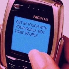 a person holding a cell phone in their left hand with the text get in touch with your goals, not toxic people