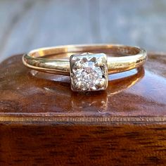 a diamond ring sitting on top of a wooden box