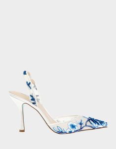 a pair of white high heels with blue flowers on them