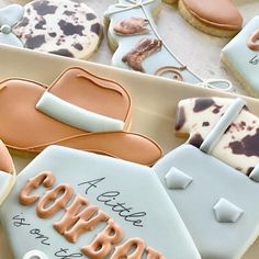 decorated cookies in the shape of cowboy hats and lasso boots are displayed on a table