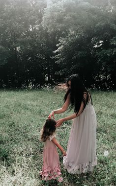 a mother and daughter playing in the grass