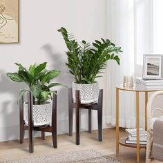 two potted plants sitting on top of wooden stools in a living room next to a window