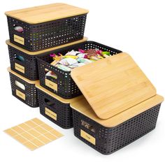 four black baskets with bamboo lids and dividers are stacked on top of each other