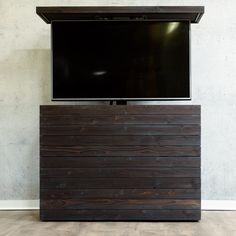 a flat screen tv mounted to the side of a wooden entertainment center on top of a hard wood floor