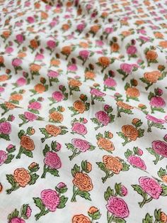 an image of a flowered fabric with pink and orange flowers on white groundcloth