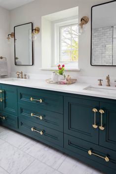 a bathroom with two sinks and green cabinets