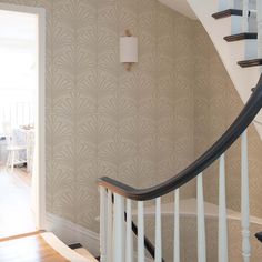 a spiral staircase in a house with beige wallpaper