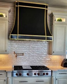 a stove top oven sitting inside of a kitchen next to white cabinets and counter tops