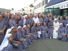 a group of people standing next to each other in front of a building