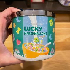 a hand holding a can of lucky marshmallows