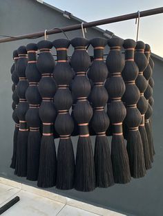 a bunch of black tassels hanging from a clothes line