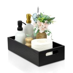 a black tray with soap, toiletries and flowers in it