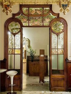 an ornate wooden door with glass panels on the top and bottom, in front of a doorway