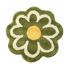 a green and white rug with a yellow flower on it's center, against a white background