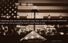 an american flag with a quote written on it in front of flowers and a lamp post