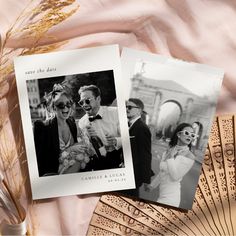 two wedding photos are laying next to each other on a pink cloth with gold fan