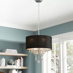 a chandelier hanging from the ceiling in a room with blue walls and shelves