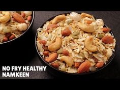 two bowls filled with nuts and granola on top of a black table next to each other