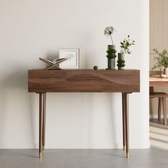 a wooden table with two vases sitting on it's sides next to a white wall