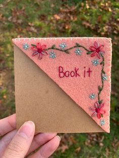 someone is holding up a pink felt book