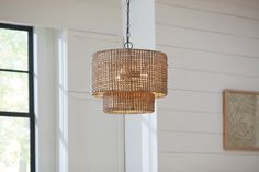 a chandelier hanging from the ceiling in a room with white walls and windows