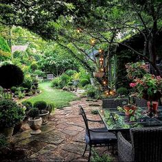 an outdoor dining area with tables and chairs, surrounded by greenery in the background