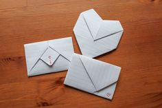 two envelopes are sitting on a wooden table