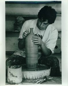 a man is making a vase out of clay