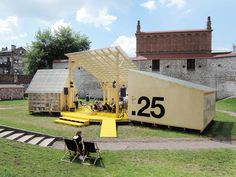 a person sitting in a chair on top of a field next to a large structure