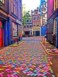 an empty street is decorated with multicolored tiles and words that read amsterdam is pretty awesome