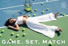 a woman laying on top of a tennis court next to a racket and balls